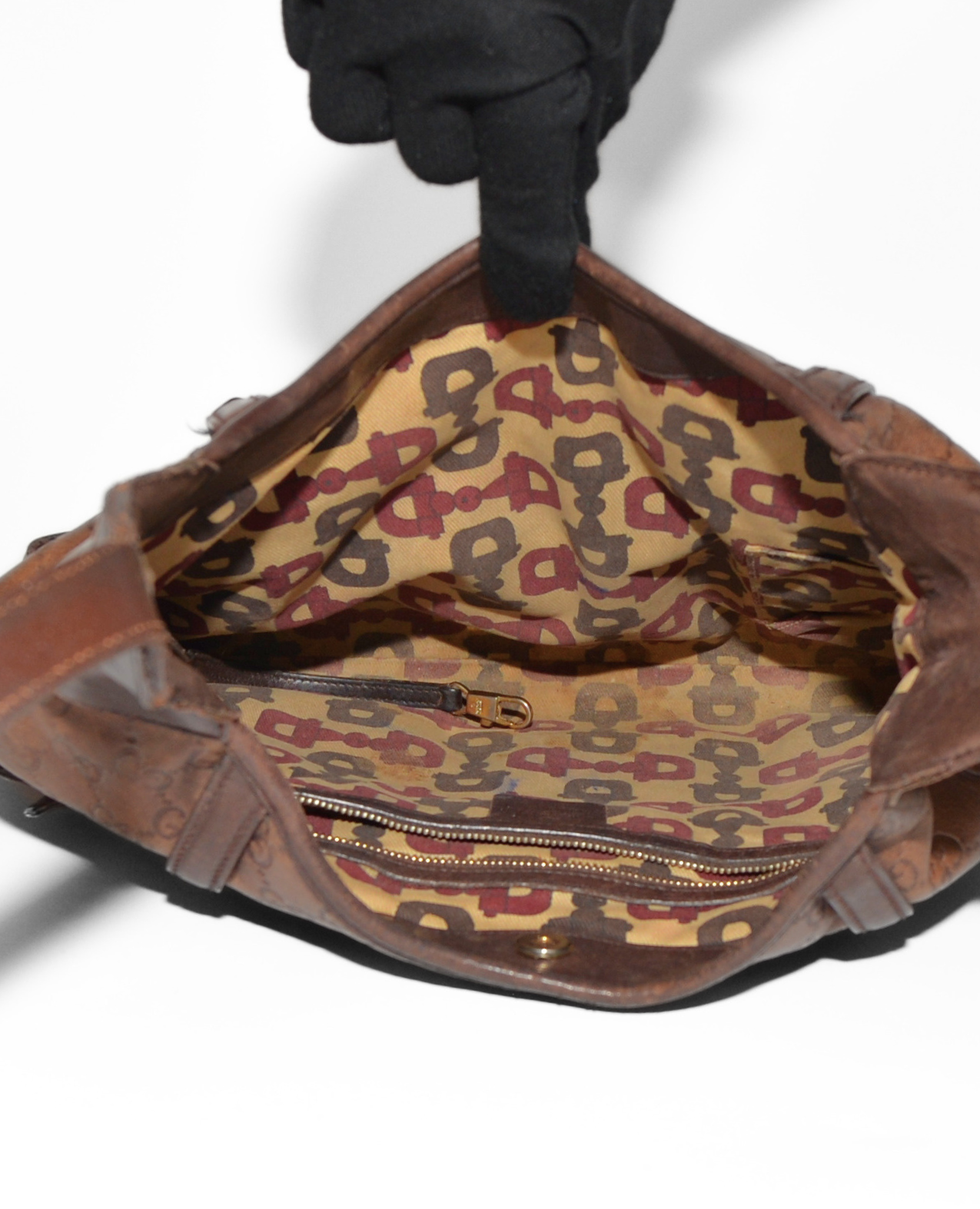 Open brown leather Gucci shoulder bag with vintage luxury monogram fabric interior and high-end stitching details. - Gucci Guccissima Leather Horsebit Shoulder Bag