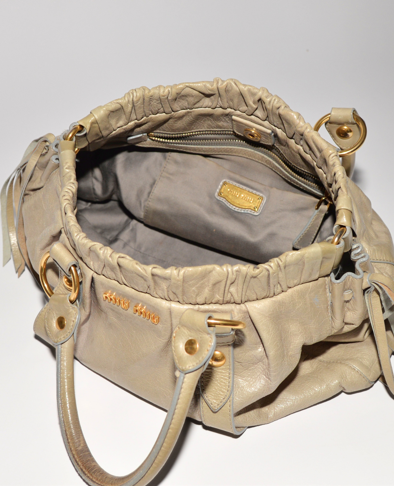 Beige Miu Miu Vitello leather handbag with ruched top, gold hardware, and monogram plaque interior, vintage luxury designer. - Miu Miu Vitello Leather Handbag